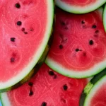 Slice of watermelon showing vibrant red flesh, macro lens, 100mm, high detail, precise focusing, controlled lighting