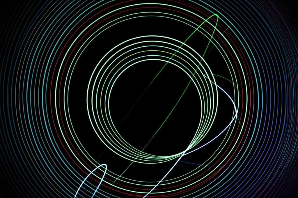 Visualizzazione 3D di un diagramma di fase complesso con traiettorie luminose a spirale e orbite chiuse su sfondo scuro, che illustra la stabilità di un sistema oscillante. Wide-angle lens, 18mm, long exposure per le tracce luminose, sharp focus sui punti di equilibrio.