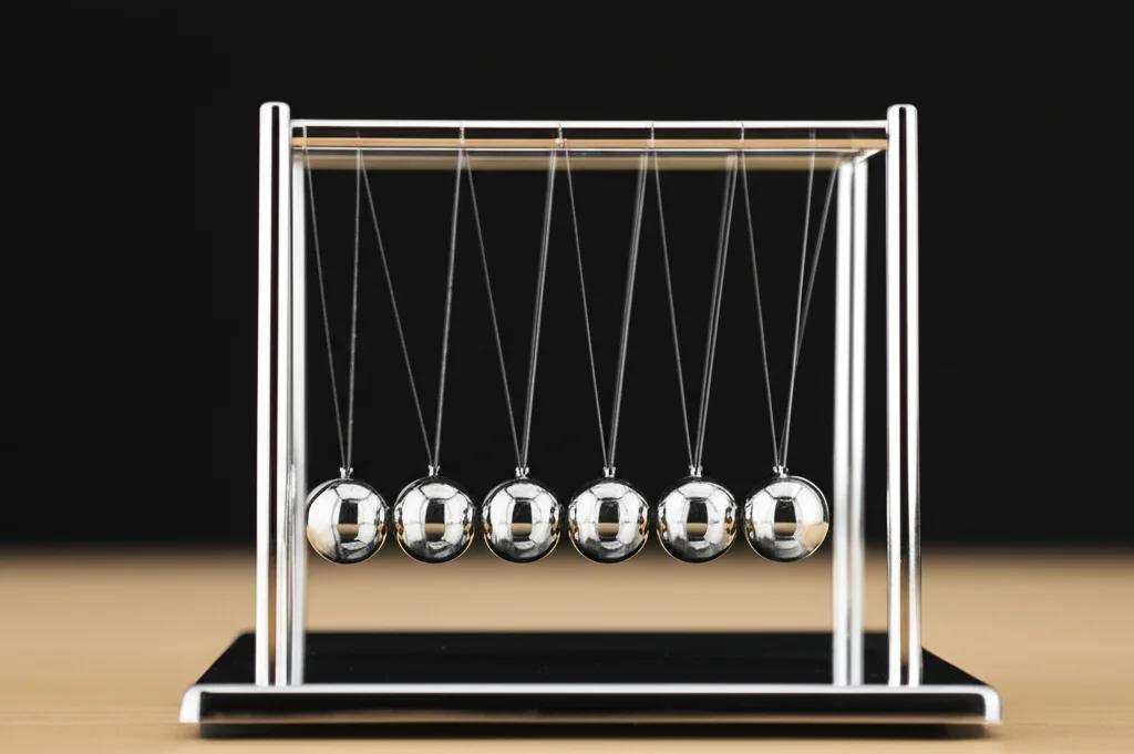 Un pendolo di Newton su una scrivania elegante, con le sfere in movimento catturate con una leggera sfocatura di movimento per indicare l'azione. Telephoto zoom, 150mm, fast shutter speed per congelare parzialmente il movimento, action or movement tracking, illuminazione da studio.