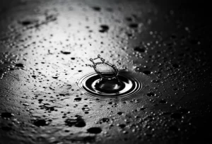 Fotografia macro di una goccia d'acqua che impatta su una superficie metallica con segni evidenti di corrosione per pitting, obiettivo 100mm macro, alta definizione dei dettagli della ruggine e dello splash della goccia, illuminazione controllata e drammatica per evidenziare la texture e il momento dell'impatto.