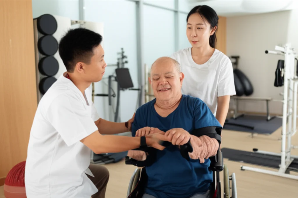 Fotografia di un fisioterapista cinese in un centro di riabilitazione che dimostra un esercizio di mobilità a una persona adulta con disabilità fisica. L'ambiente è luminoso e moderno, con attrezzi specifici sullo sfondo. Obiettivo prime, 35mm, profondità di campo per mettere a fuoco l'interazione, toni caldi e accoglienti.