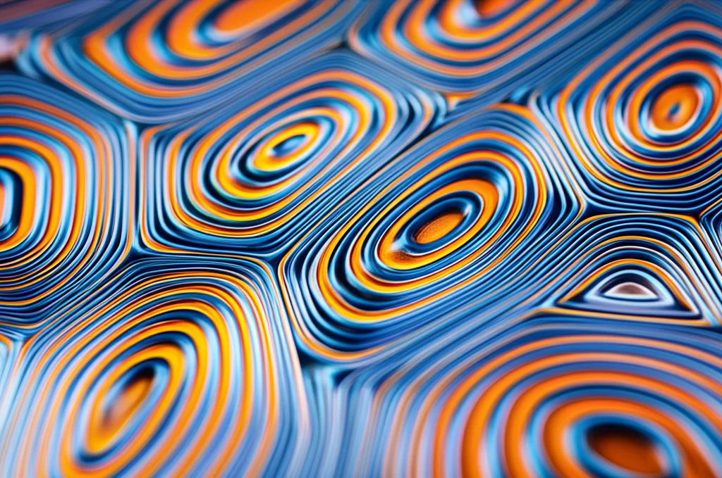 Un'immagine macro, con obiettivo da 60mm, di una rappresentazione artistica e astratta di onde di densità di spin (SDW) che si propagano su un reticolo kagome stilizzato, con illuminazione controllata per evidenziare le texture e i pattern ondulatori. Colori freddi come blu e argento per il reticolo, con onde rosse o arancioni per l'SDW, high detail, precise focusing.