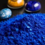 La natura morta fotorealistica, lenti macro 100mm, con due distinte pile di pigmento: vibrante polvere blu egiziana con la sua consistenza leggermente cristallina e una polvere blu ultramarina intensa profonda e intensa. Accanto a loro si trovano un frammento di antiche ceramiche dipinte egiziane e una pietra Lapis Lapis Lapis. Illuminazione controllata, dettagli elevati, focus acuto sui pigmenti.