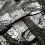 Photorealistic image of a fractured coal sample under laboratory conditions, macro lens, 60mm, high detail, controlled lighting.