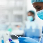 A composite image showing a healthcare worker looking at lab results related to blood coagulation, with a subtle background suggesting a hospital in Ethiopia, photorealistic, 35mm lens perspective.