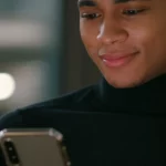 Photorealistic portrait of a celebrity looking amused while scrolling on a phone, 35mm lens, depth of field, natural light.