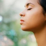 35mm portrait, depth of field, representing a person taking a deep, clear breath, with subtle background elements hinting at cellular health and clean air.