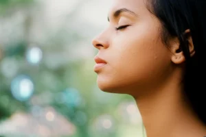 35mm portrait, depth of field, representing a person taking a deep, clear breath, with subtle background elements hinting at cellular health and clean air.