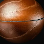 A photorealistic image depicting a cross-section of a 3D object, perhaps a sphere or a slightly asymmetric convex shape. The object has a clearly defined insulating layer around it. Part of this layer is a uniform minimum thickness (ℓ_min), and on top of that, in certain regions, the insulation is visibly thicker, showing an optimal, non-uniform distribution. Use a macro lens, 85mm, with high detail and controlled lighting to emphasize the different thicknesses and textures of the insulating material.