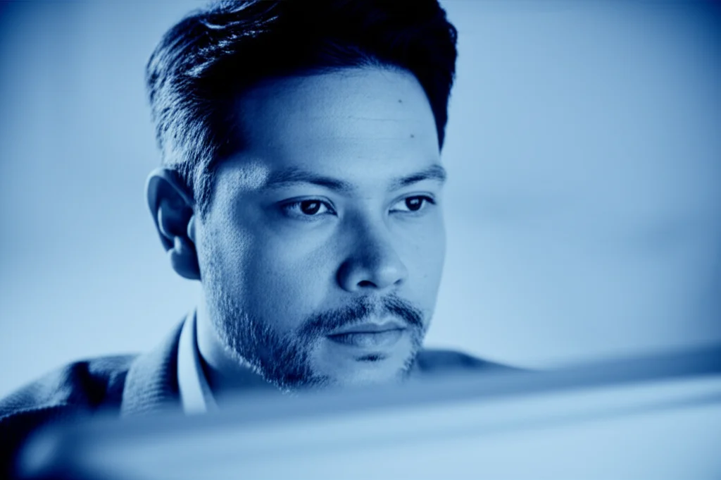 portrait photography, 35mm portrait, researcher looking at data on a screen, blue and grey duotones, focus on eyes