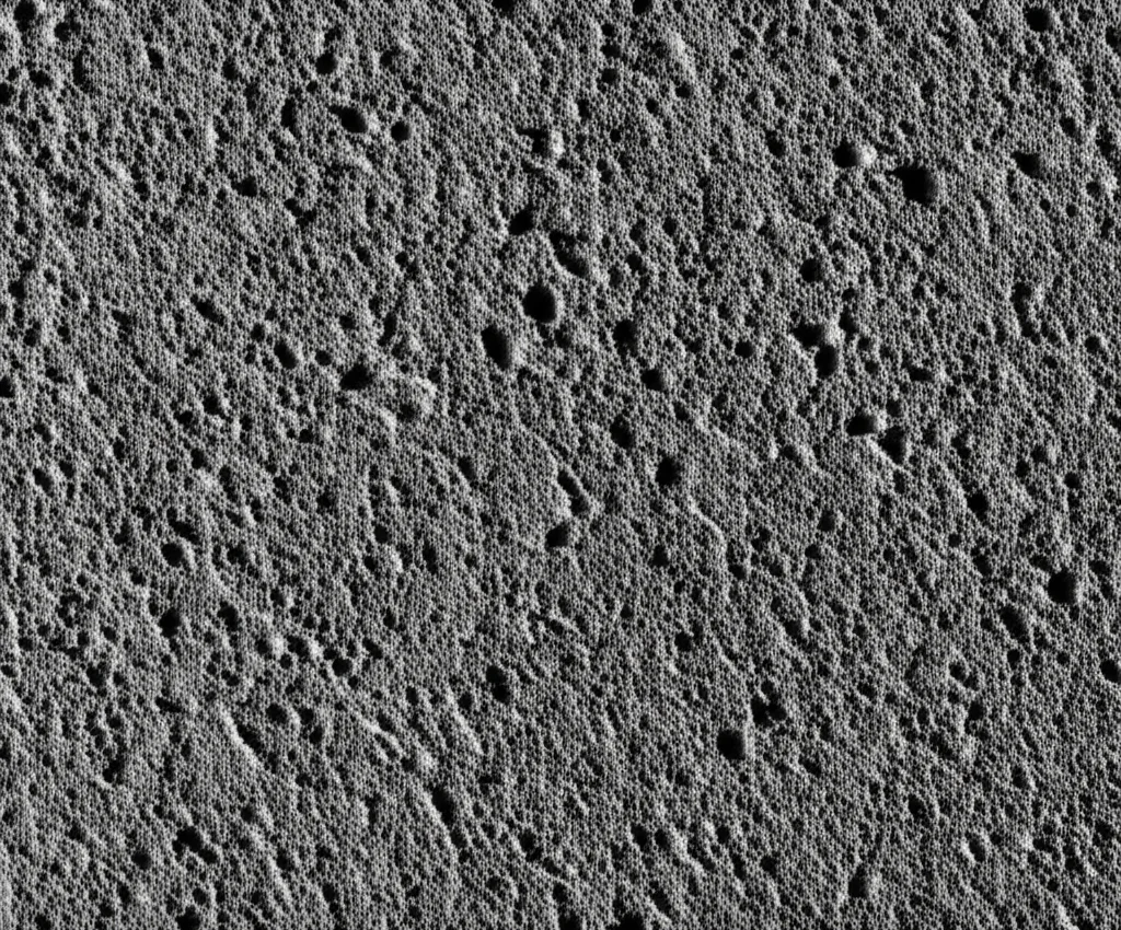 Photorealistic image showing a close-up, macro shot of the surface of a fibrous sound-absorbing material sample. High detail, 100mm macro lens, precise focusing, controlled lighting to highlight the texture and porous nature.