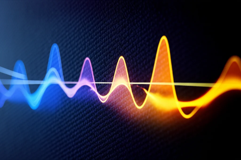 Abstract conceptual visualization of 'fingerprint spectra'. Two sets of graphs are overlaid or side-by-side. Each graph shows three distinct, glowing peaks. One set, perhaps in cool blue and violet tones, represents a baseline. The second set, in warmer orange and yellow tones, shows the peaks slightly shifted in position and altered in height, visually representing the changes due to varying electron mobility or concentration. Macro lens, 90mm, high detail, precise focusing, controlled lighting, on a dark, subtly textured background.
